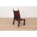 A tribal hardwood and hide low chair,