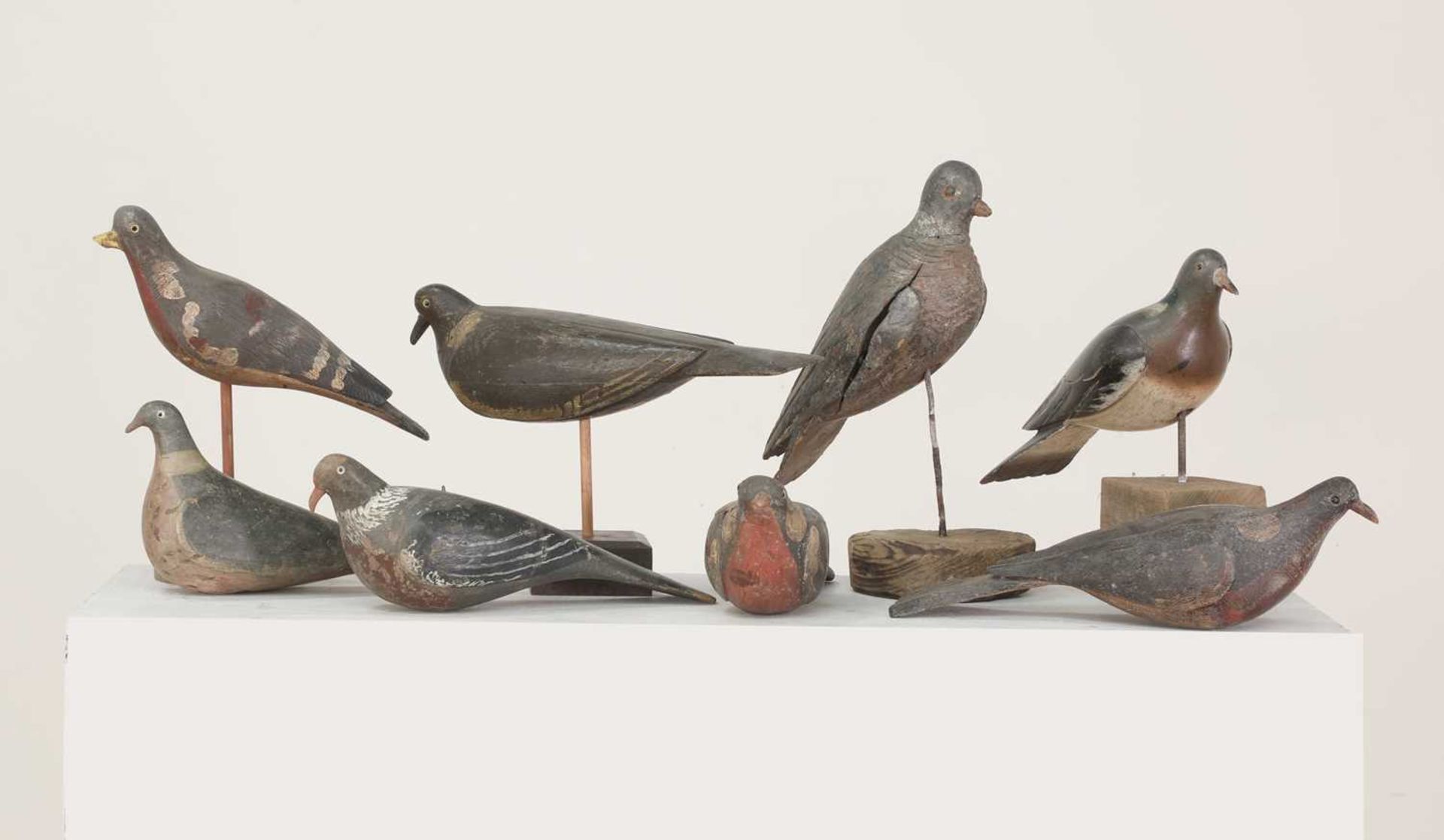 A flock of carved wooden and painted decoy pigeons,