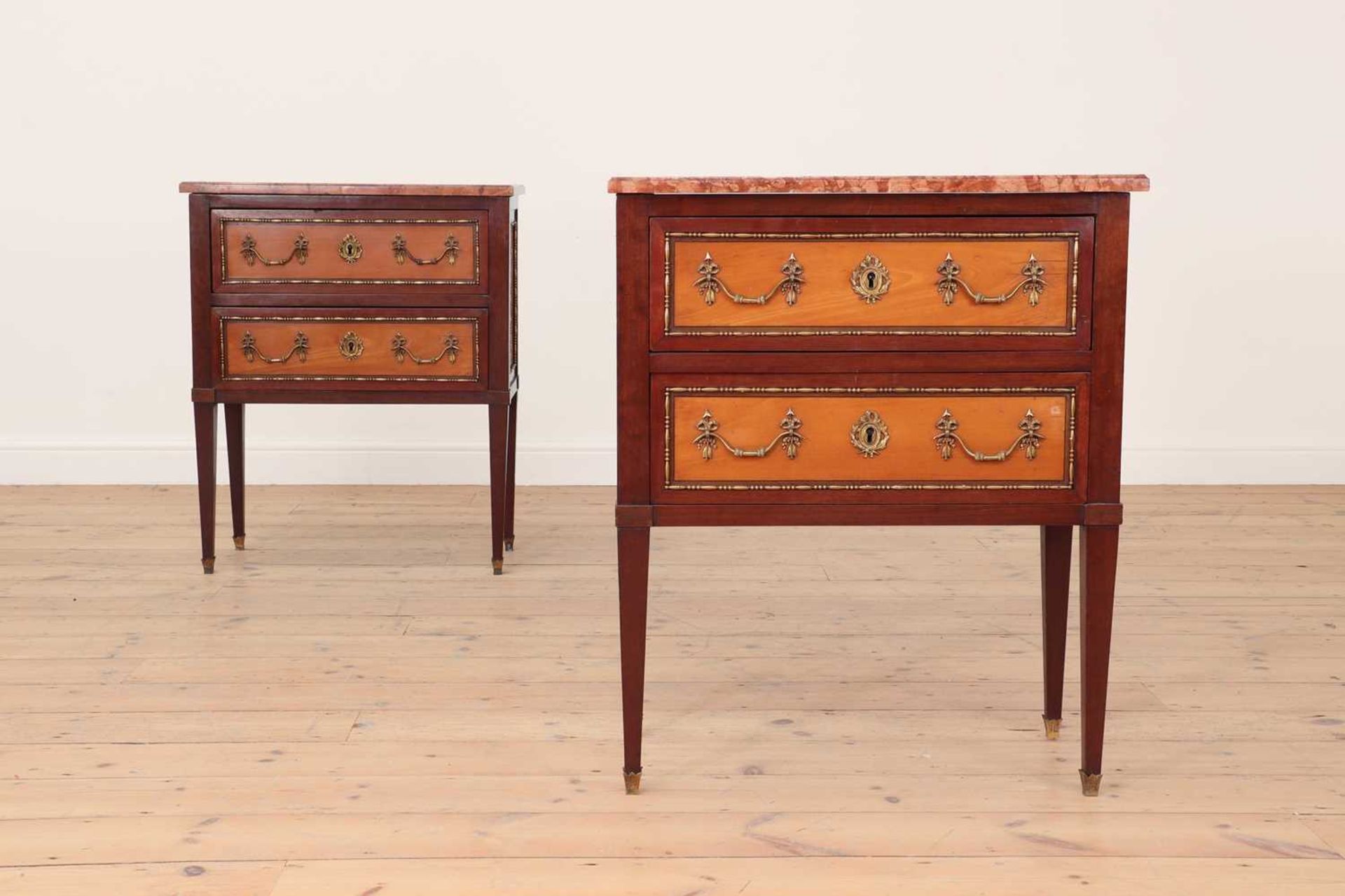 A pair of small Louis XVI-style mahogany, satinwood and gilt-metal commodes,