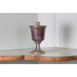 A small unmarked silver communion cup with paten,