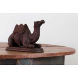 A carved hardwood inkwell in the form of a seated camel,