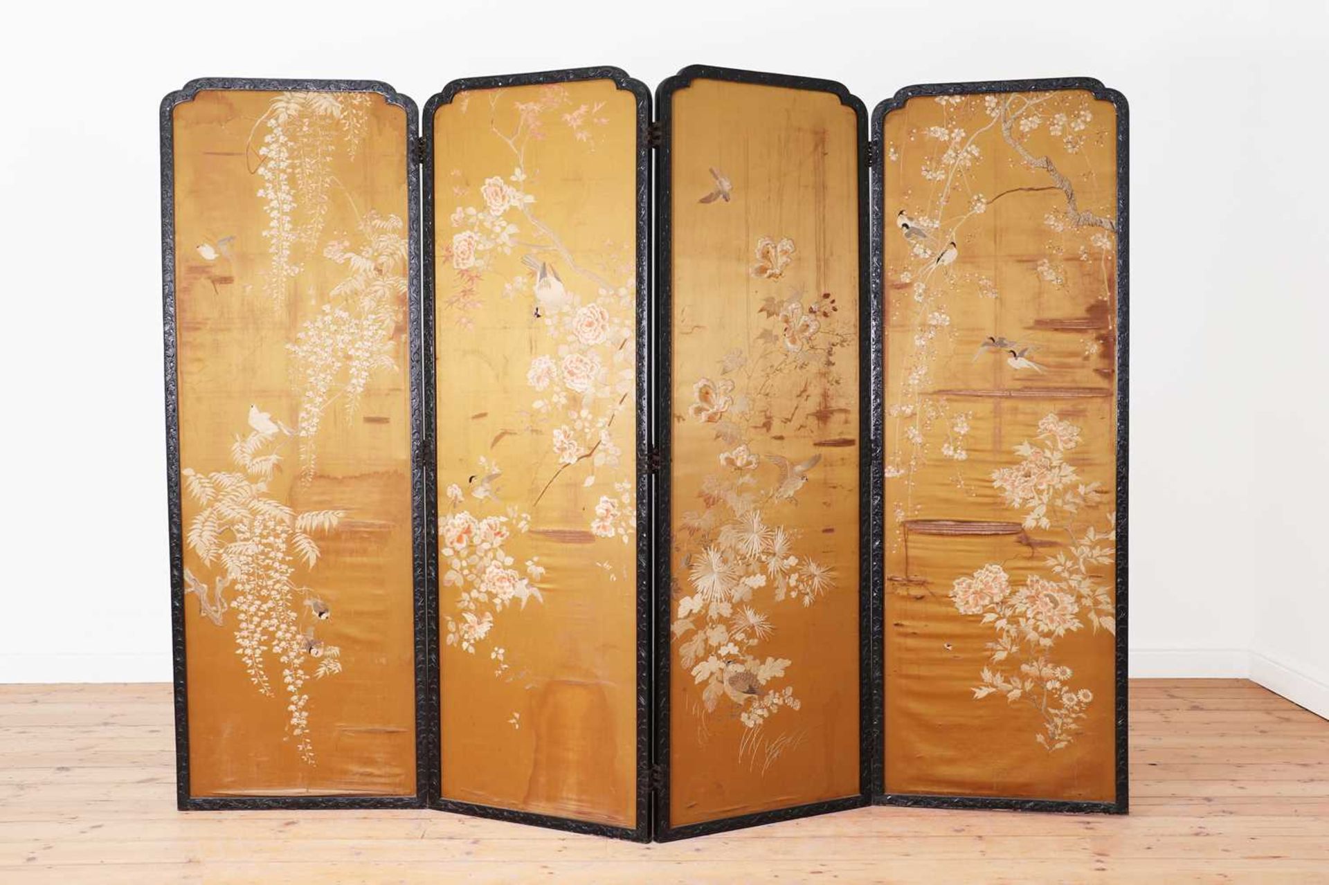 An ebonised softwood four-fold screen,