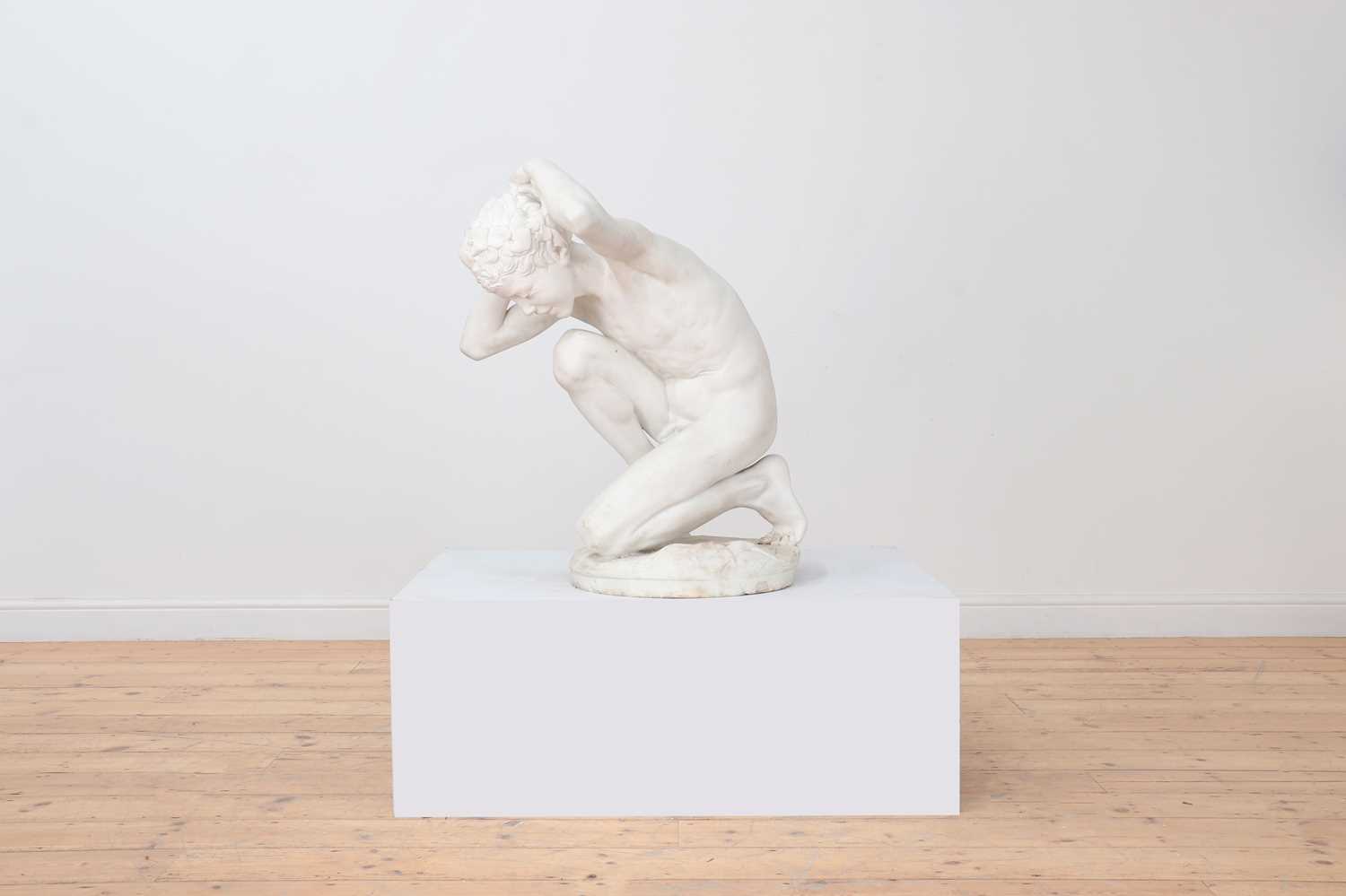 A marble figure of a crouching faun,