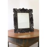 A pierced and carved cedar mirror,