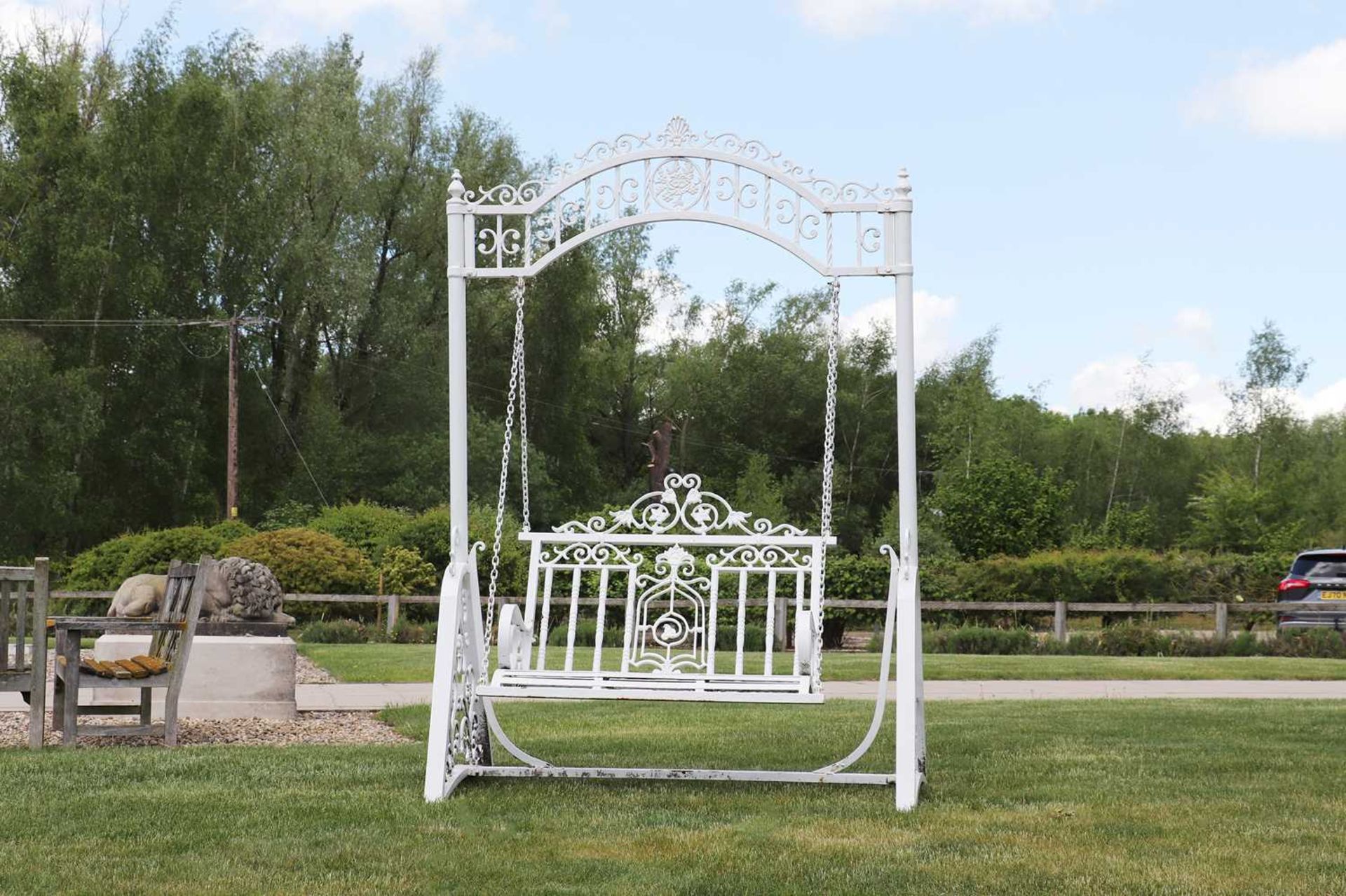 A painted ironwork garden swing seat,