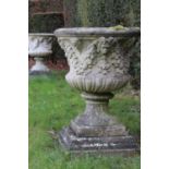 A pair of weathered composite stone campana urns,