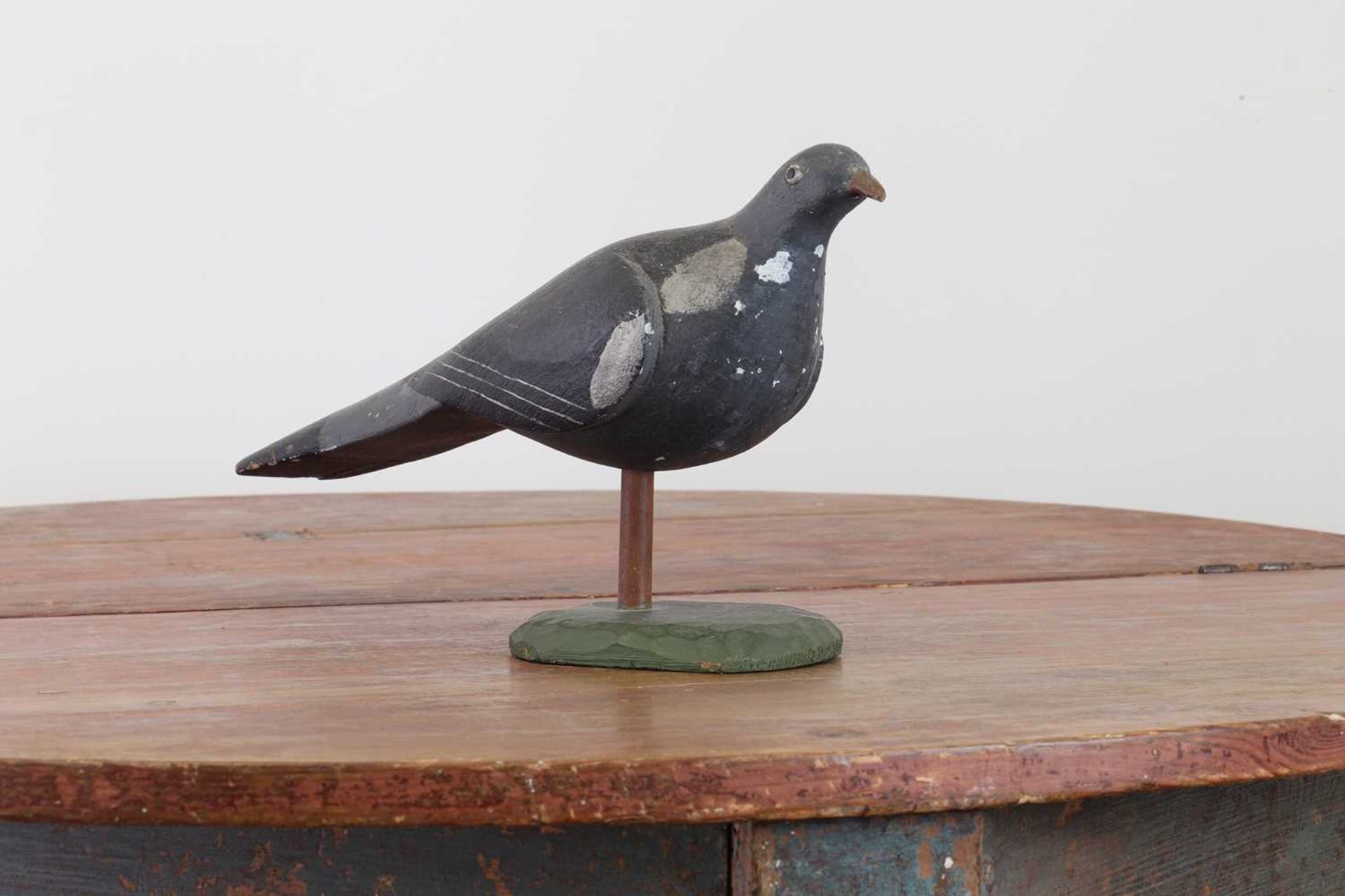 A carved and painted decoy pigeon,
