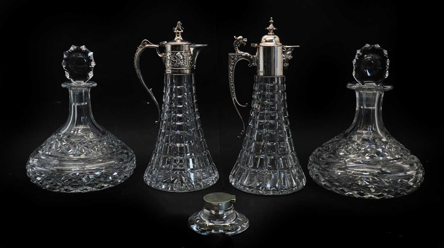 A near pair of silver topped cut glass claret jugs