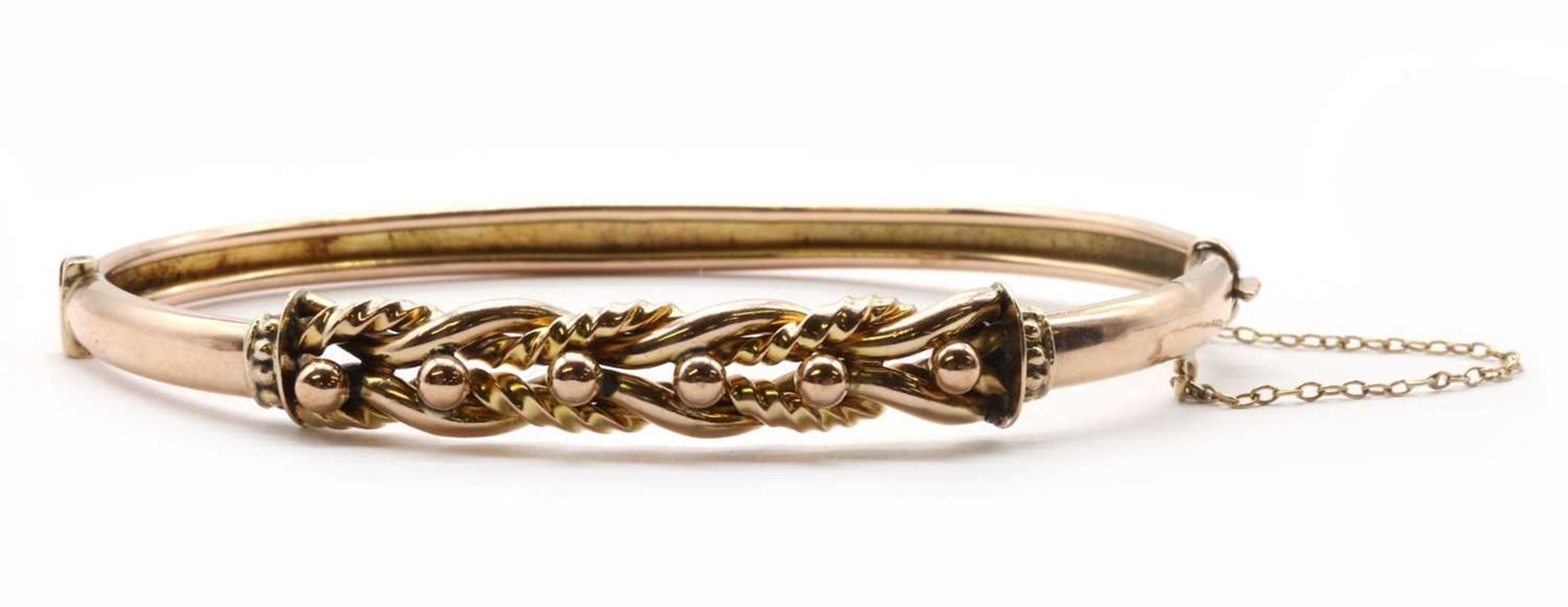 A gold hollow oval hinged bangle,