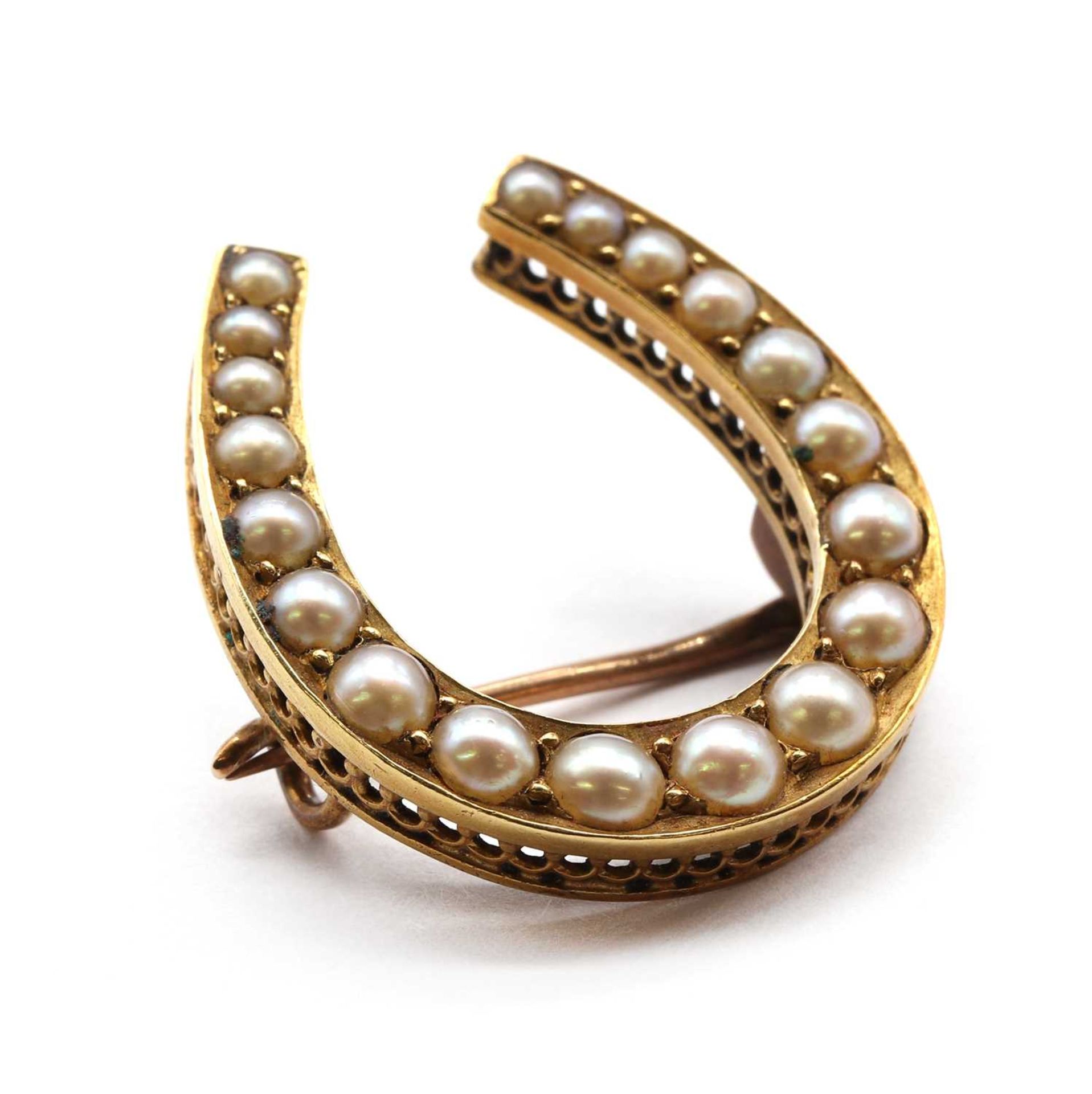 A gold split pearl horseshoe brooch,