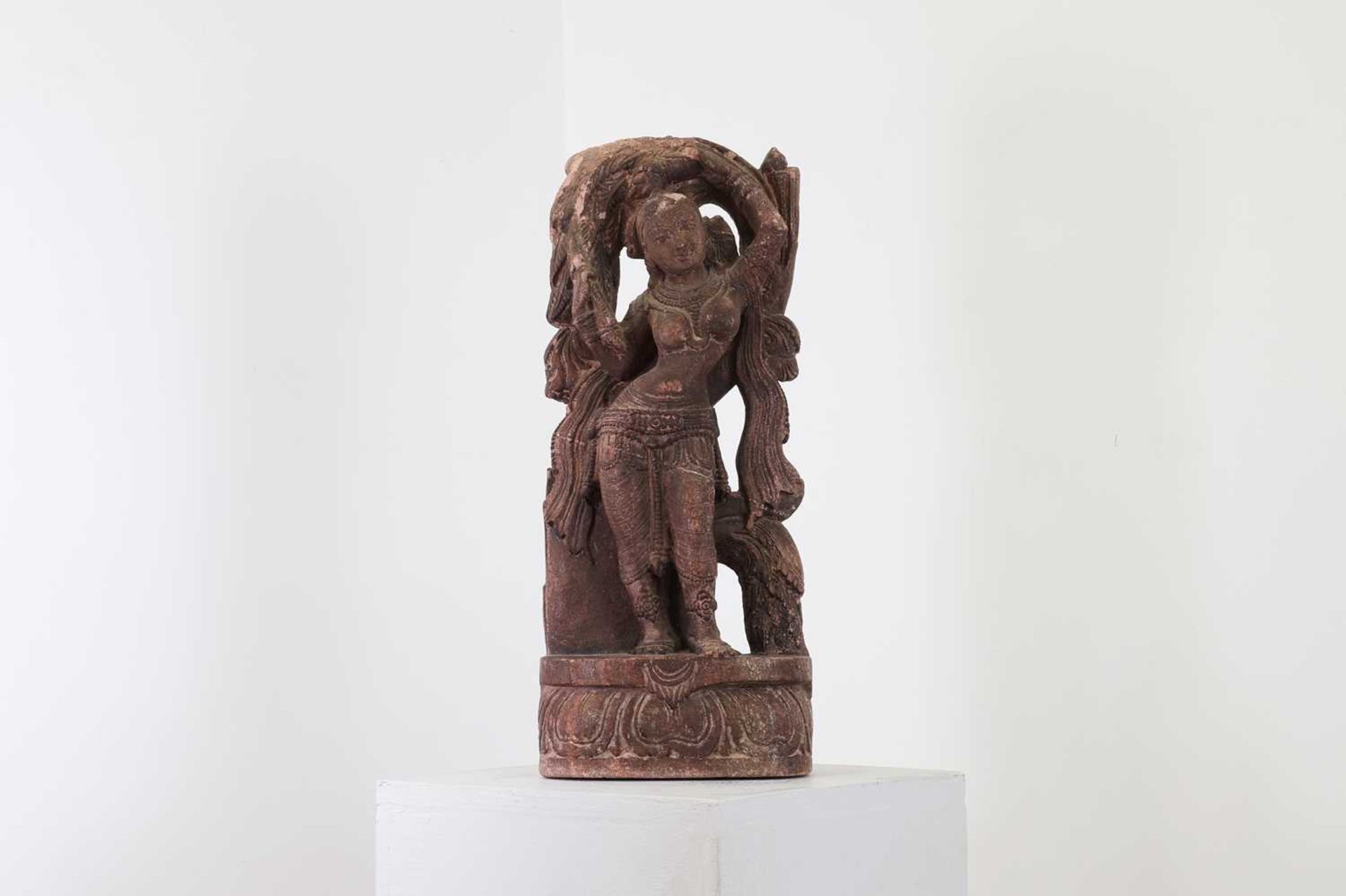 A carved sandstone or possibly composite figure of a dancing apsaras,