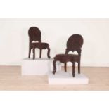 A pair of carved teak chairs,