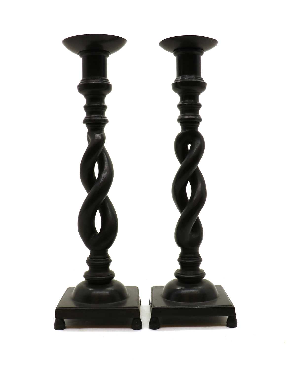 A pair of patinated bronze pricket candlesticks,