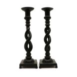A pair of patinated bronze pricket candlesticks,