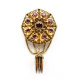 A Victorian gold garnet set Etruscan style shield form brooch,