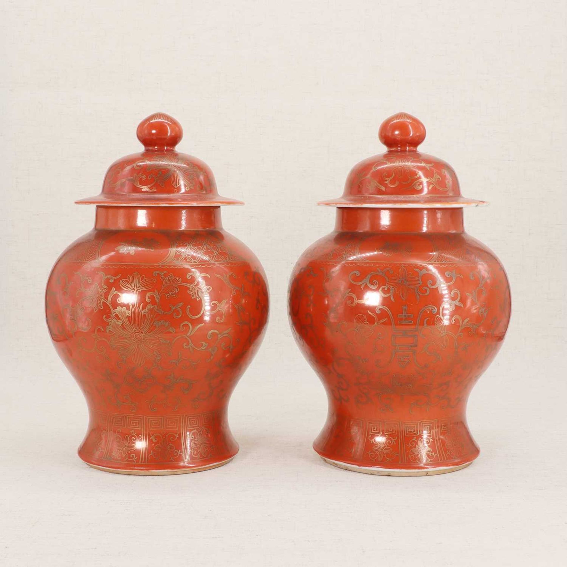 A pair of Chinese coral-ground vases and covers,