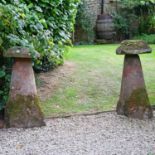 A pair of tall sandstone staddle stones,