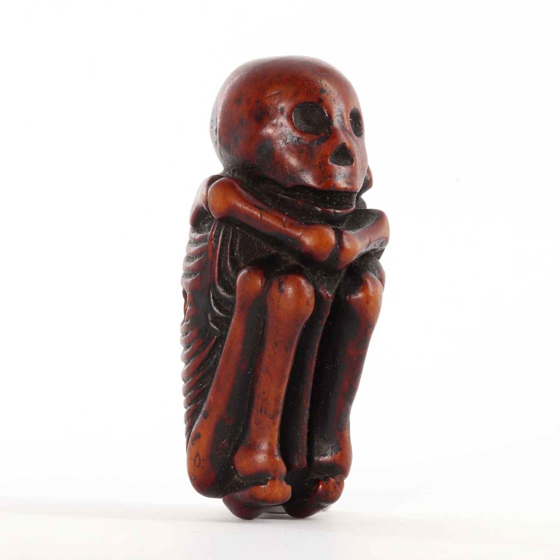 A Japanese carved boxwood netsuke depicting a skeleton,