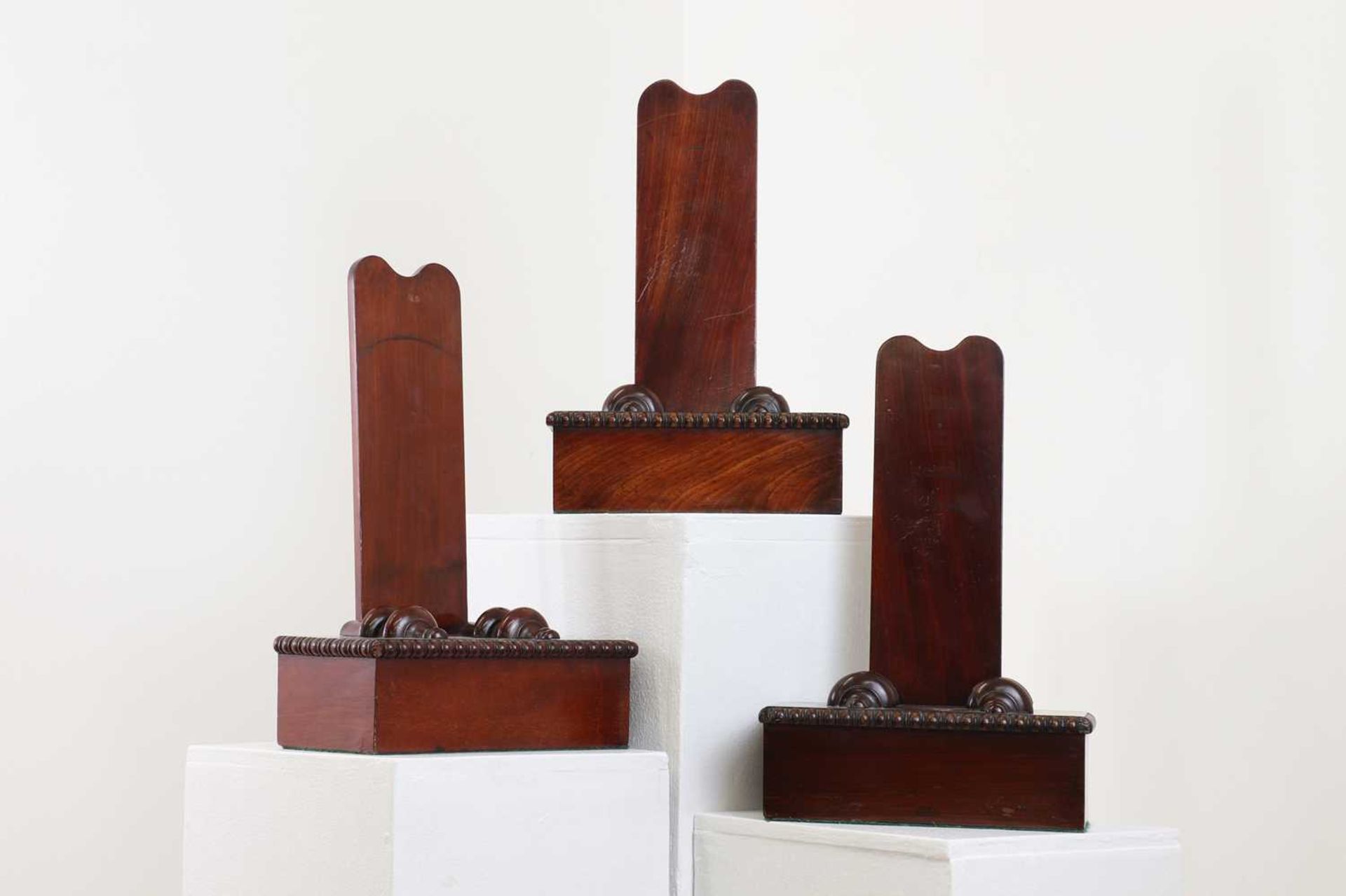 A group of three mahogany plate stands,
