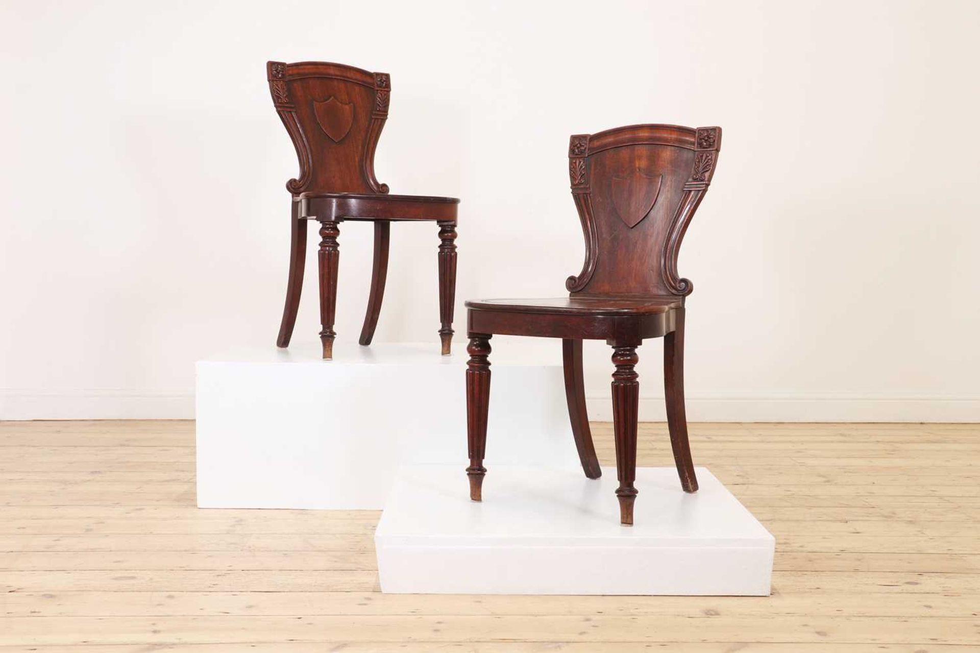 A pair of George IV mahogany hall chairs,