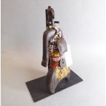 A Namji (Cameroon) doll with beaded decoration and leather amulet, on custom stand (doll 27.5cm;