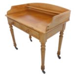A 19th century waxed pine washstand; the three-quarter galleried top above two half-width drawers