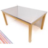 A modern steel-topped table with natural beech base and square legs (152cm wide x 91.5cm deep x 75.