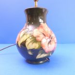 A Moorcroft table lamp of Hibiscus pattern (24cm high x 18cm wide)
