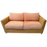A large conservatory-style wickerwork sofa with cushions (175cm wide x 87cm deep)