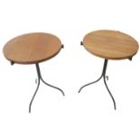 A pair of circular topped hardwood conservatory-style occasional tables with wrought iron tripod-