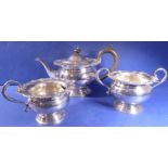 An ornate three-piece silver-plated tea set