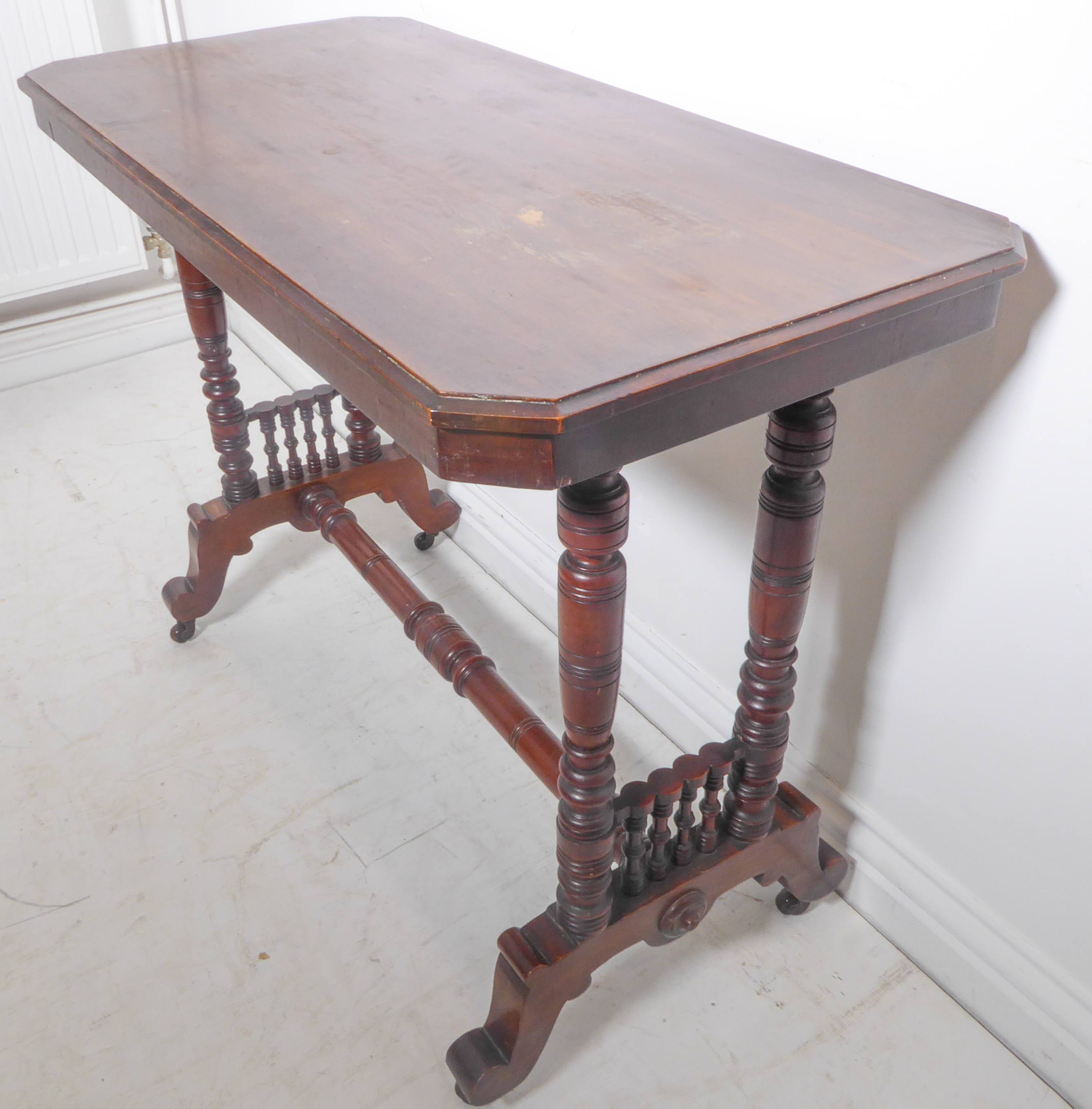 An Edwardian mahogany occasional table – rectangular form with canted corners and four turned