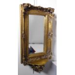 A heavy antique-style gilt-framed wall-hanging looking glass –  the swept cushion moulded