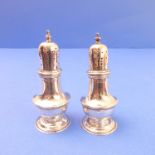A pair of early 20th century baluster-shaped hallmarked silver pepperettes, London hallmarks,