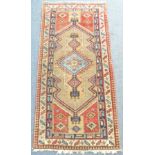 A hand knotted Eastern carpet; light blue lozenge against a beige and red ground (230xm x 111cm)