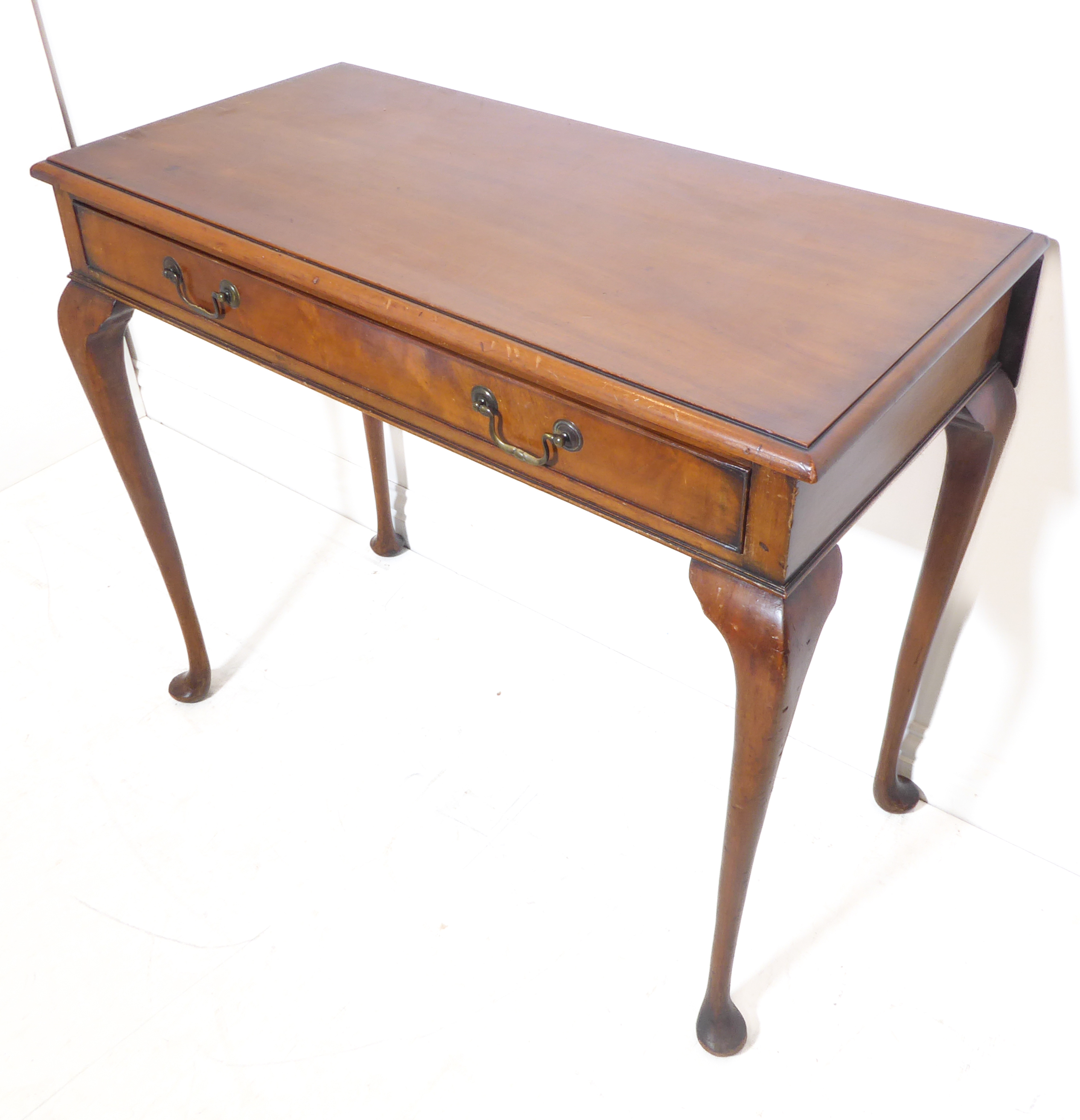 An early 20th century mahogany side table in Georgian-style – the thumbnail moulded top above a