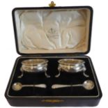 A pair of silver salts by George Unite (Birmingham 1919) with two unassociated salt spoons in a Butt