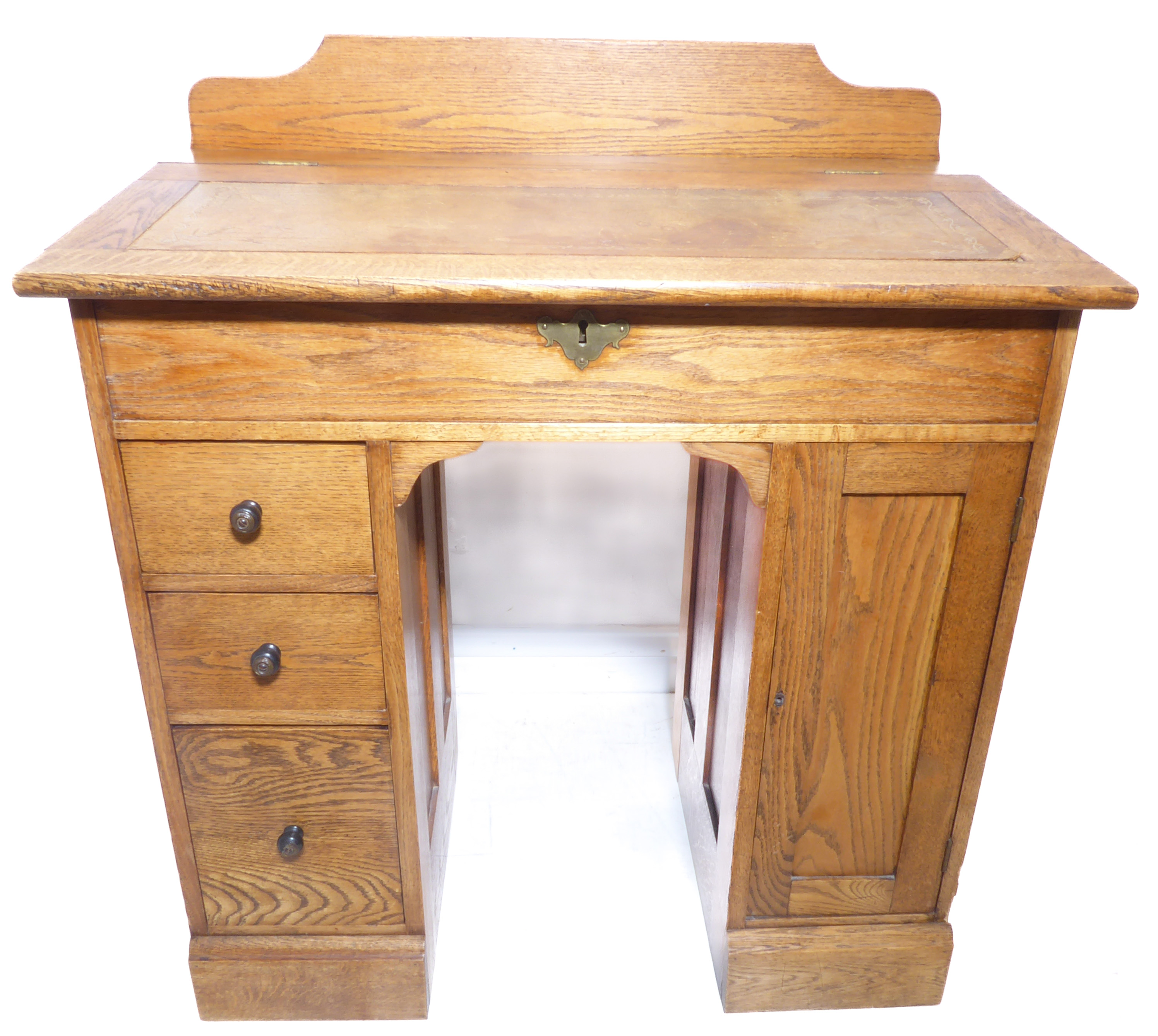 An early 20th century oak desk of small proportions – the angular hinged leather-inset top above