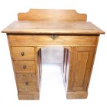 An early 20th century oak desk of small proportions – the angular hinged leather-inset top above