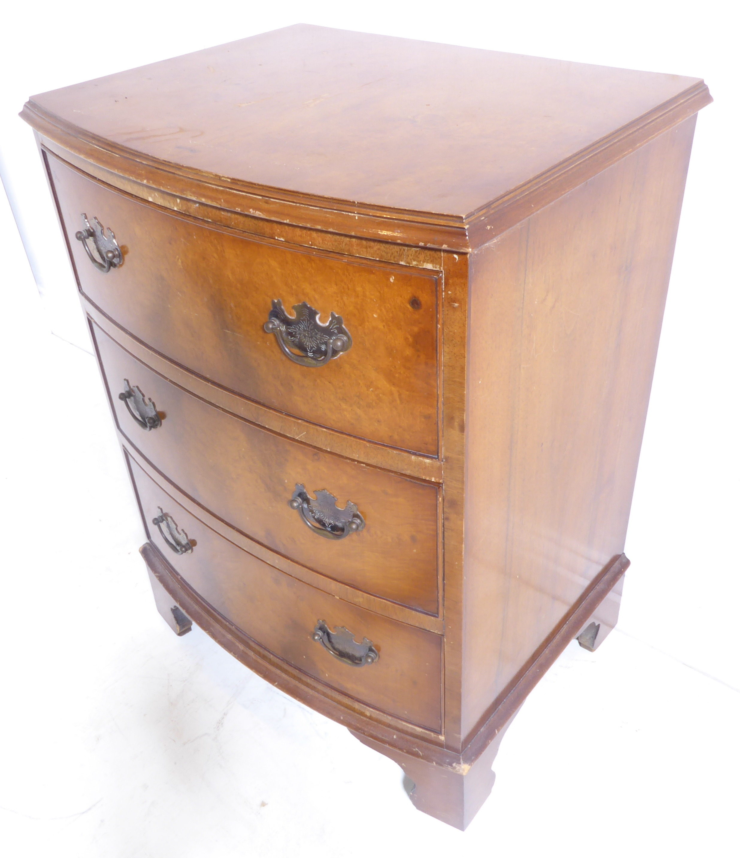 A reproduction bow-fronted walnut three-drawer chest on bracket feet (54cm wide x 43cm deepest x