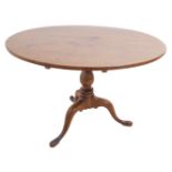 A 19th century circular oak occasional table; turned stem and on tripod base with elongated pad feet