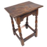 A high 17th century style oak joint stool; the slightly concave top above baluster turned supports