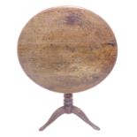 A Georgian circular tilt top oak occasional table on turned stem and tripod base (72.5cm