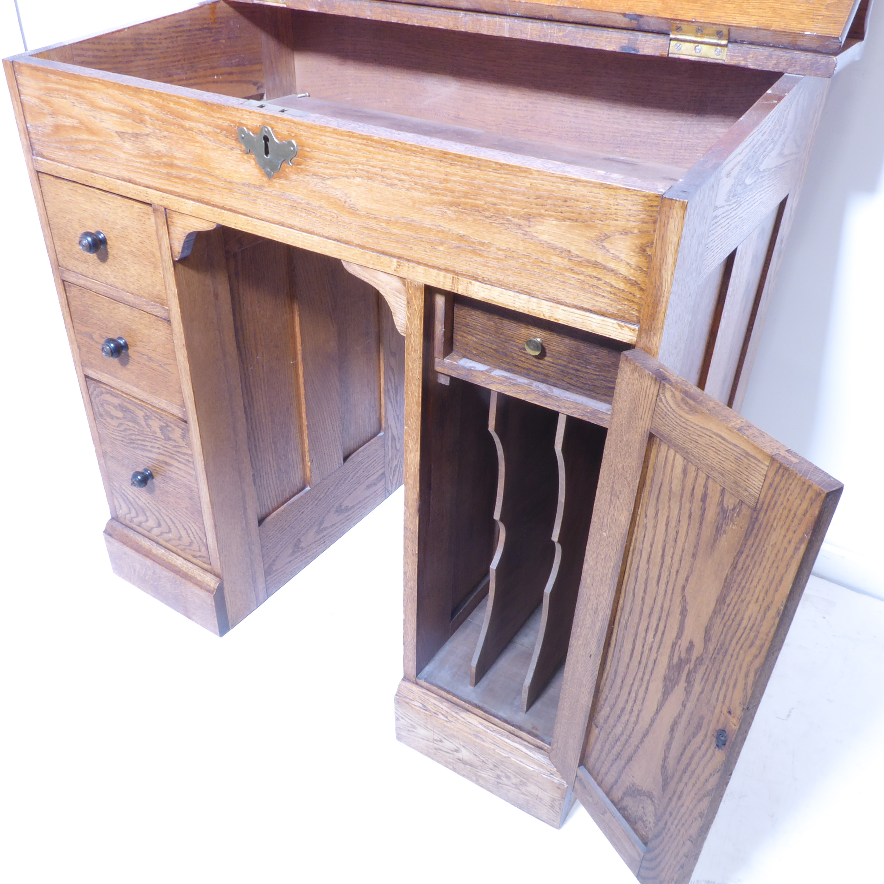 An early 20th century oak desk of small proportions – the angular hinged leather-inset top above - Image 4 of 5