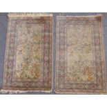 A pair of Turkish silk Hereke carpets; ivory ground with central tree of life design incorporating