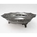 A hallmarked silver bowl; pierced swag style border and raised on three foliate cast feet, maker's