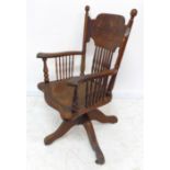 A late 19th / early 20th century American-style oak swivel desk chair; the large shaped top rail