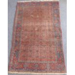 A mid 20th century Kurdish rug; North West Persia, stylised repeating patterns against a coral