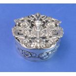 A circular hallmarked silver trinket/silver jewellery box; the elaborately decorated and pierced