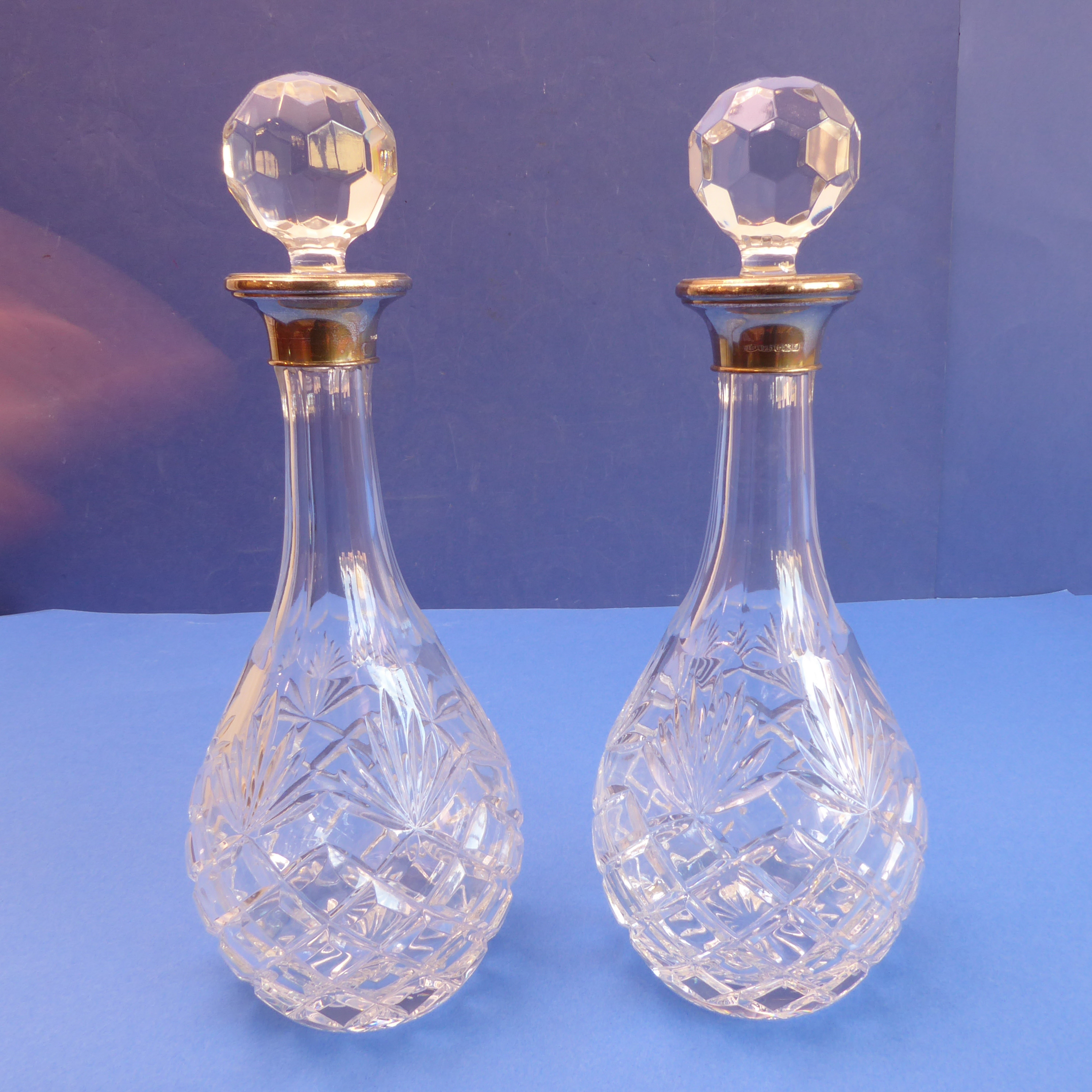 A pair of modern cut-glass club-shaped decanters; each with hallmarked silver-mounted collar (31.5cm